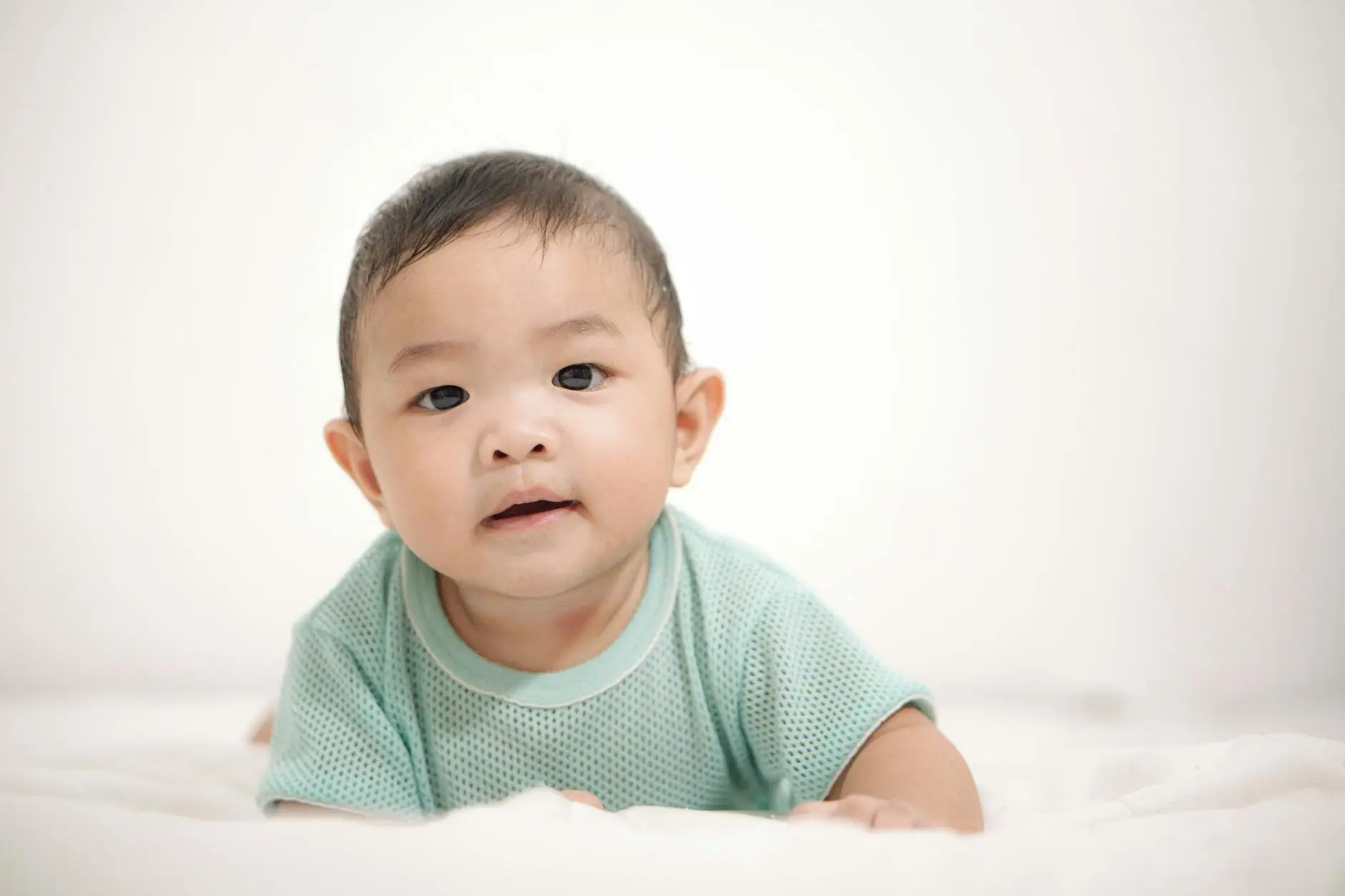 Gambar bayi yang mengalami perut kembung dengan latar belakang ibu yang memberikan perawatan alami untuk membantu mengatasi gejala tersebut